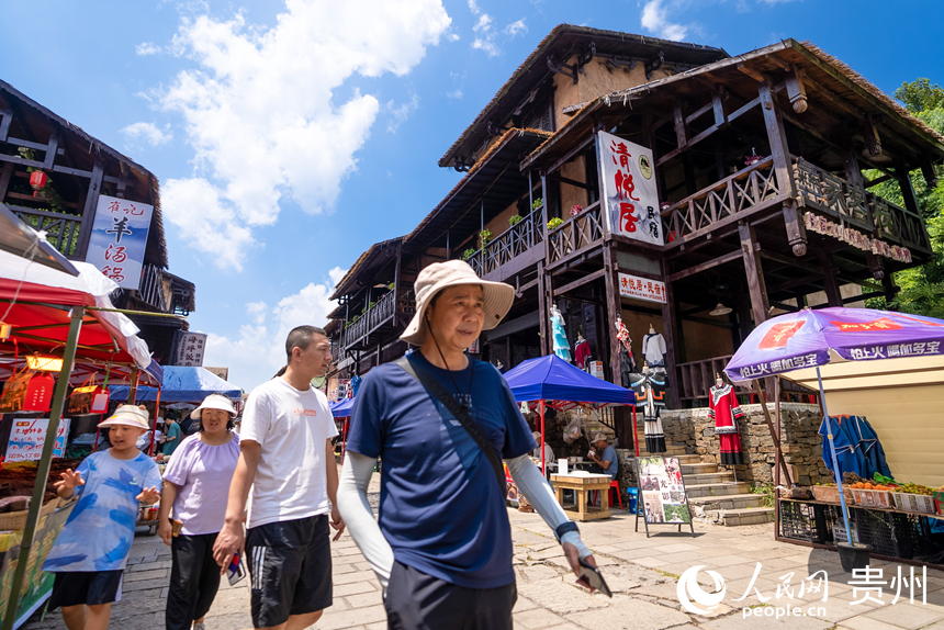 游客在景区内的海坪彝族特色旅游度假小镇参观游览。人民网记者 涂敏摄