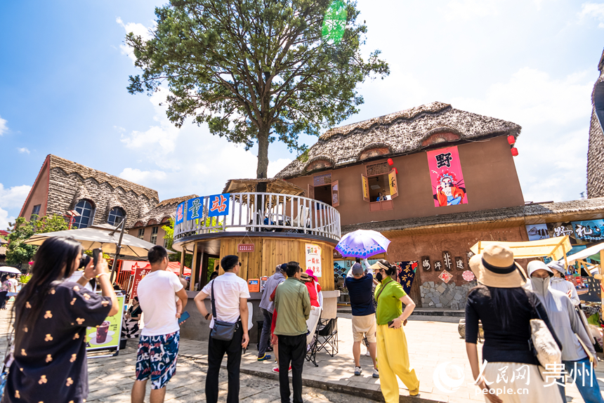 游客在景区内的海坪彝族特色旅游度假小镇观看表演。人民网记者 涂敏摄